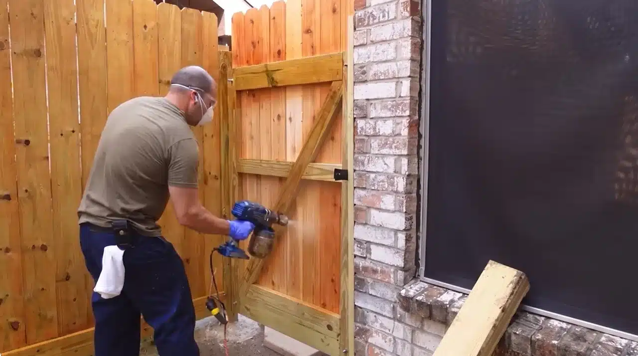 Installing a wooden fence gate with diagonal support braces and heavy-duty hardware