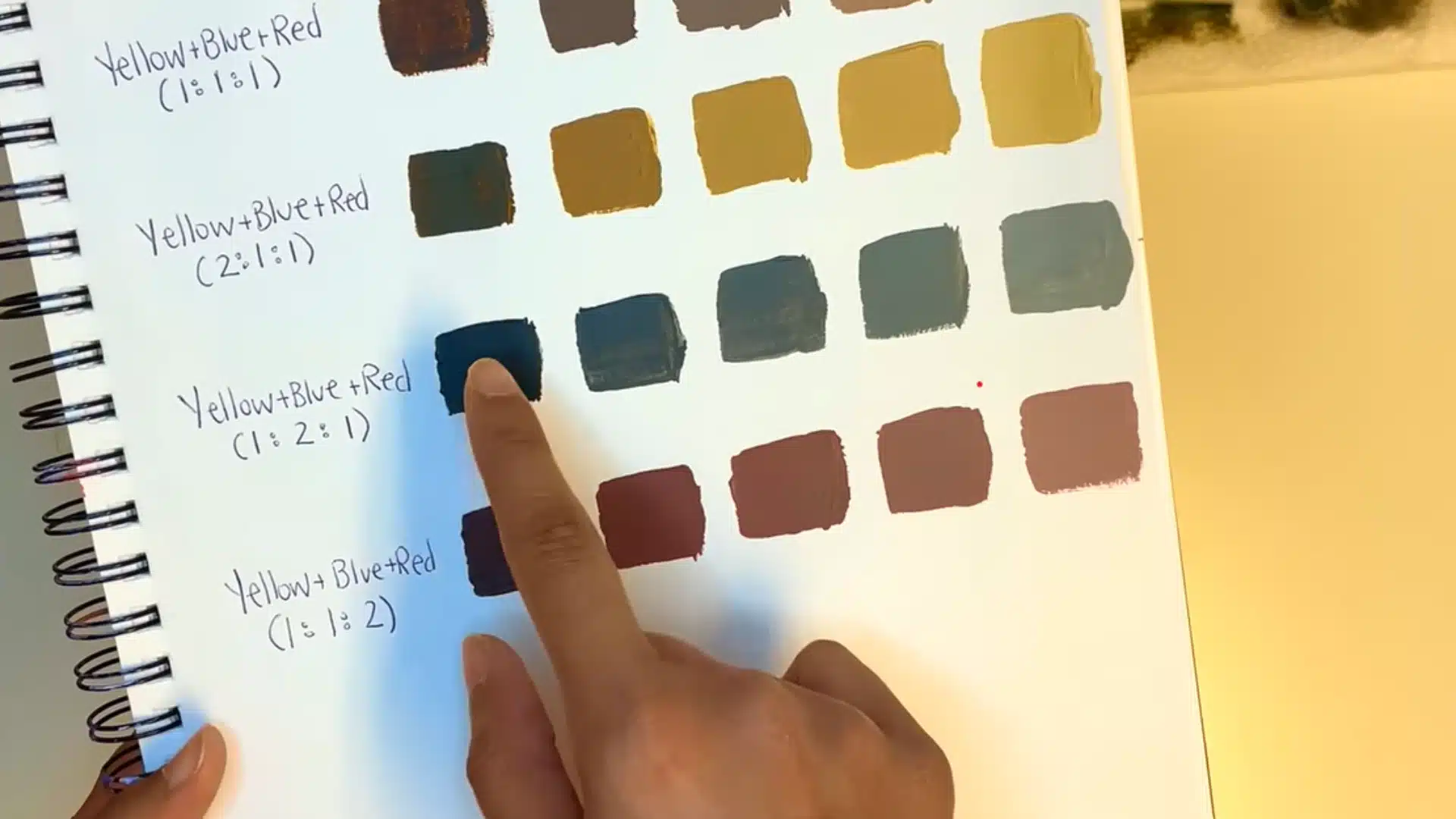 Adding a small amount of blue paint to brown to create a darker cooler brown shade.