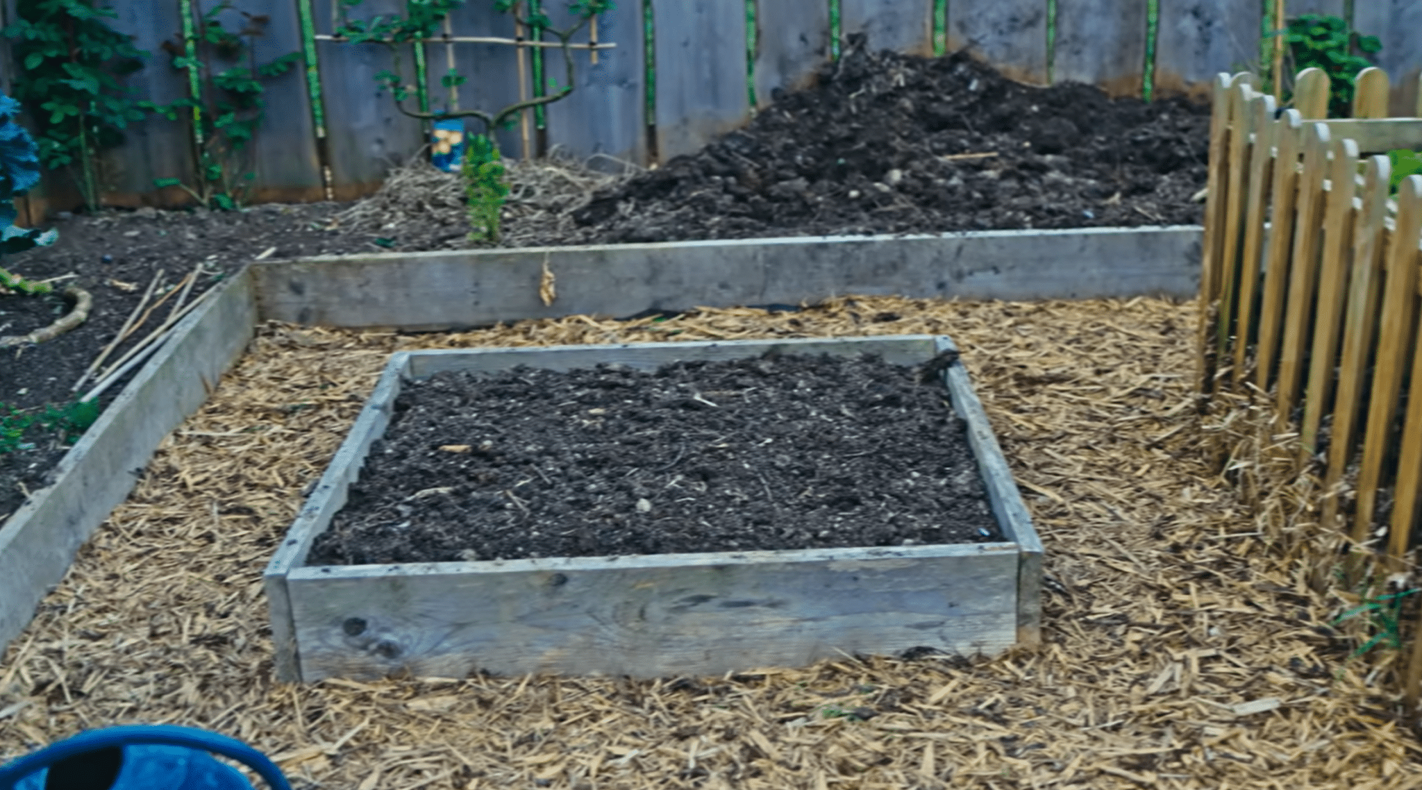 Raised garden beds divided into organized growing sections with mulched pathways and prepared soil.