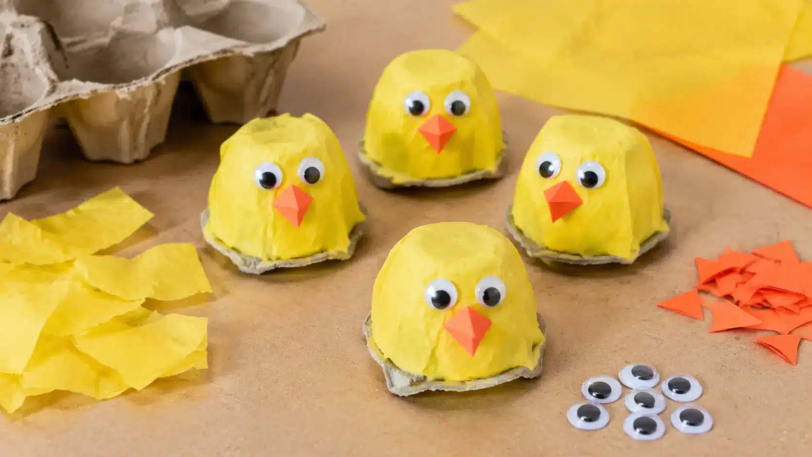 Egg carton chicks with yellow bodies and paper beaks