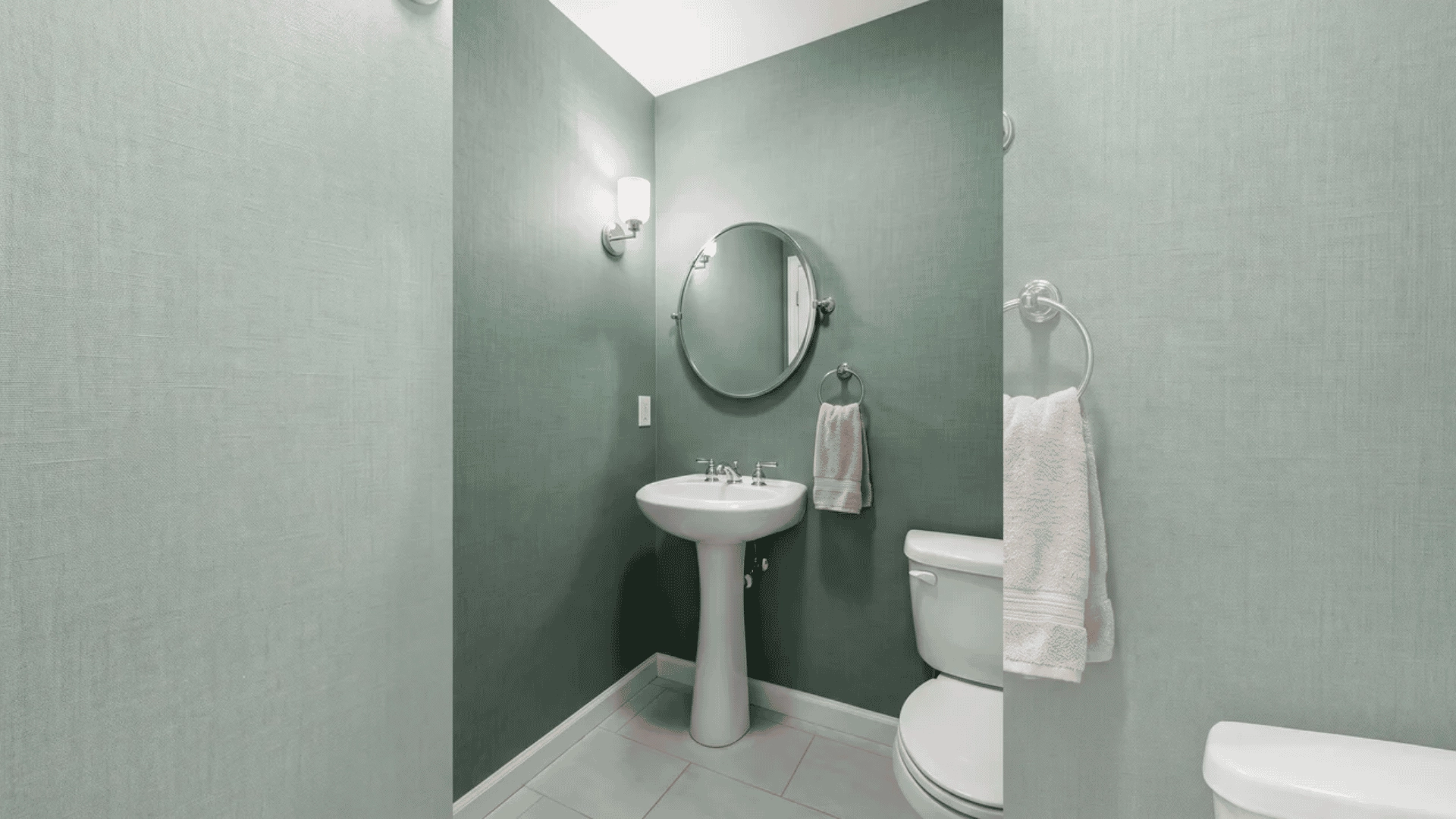 Powder room with eucalyptus green textured wallpaper
