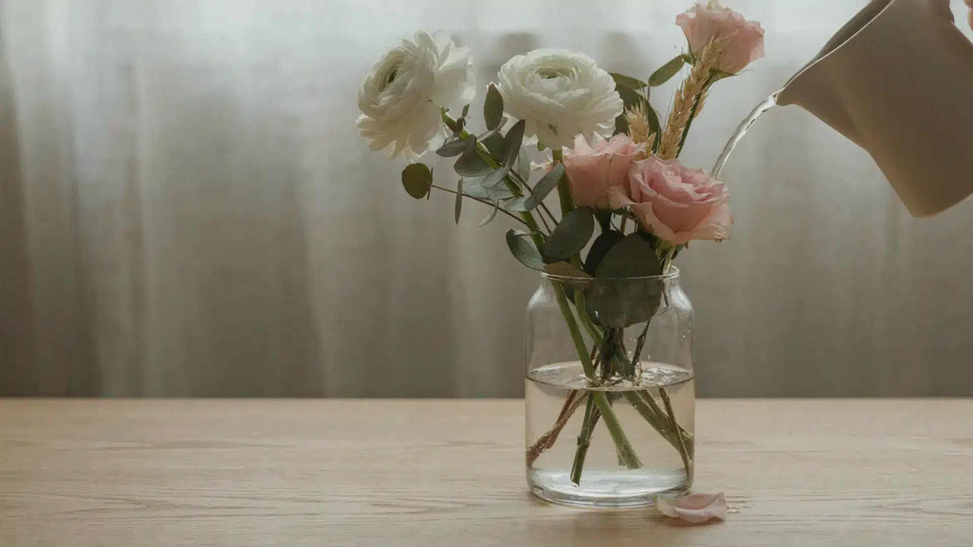 Clear vase with cut flowers and fresh water during care