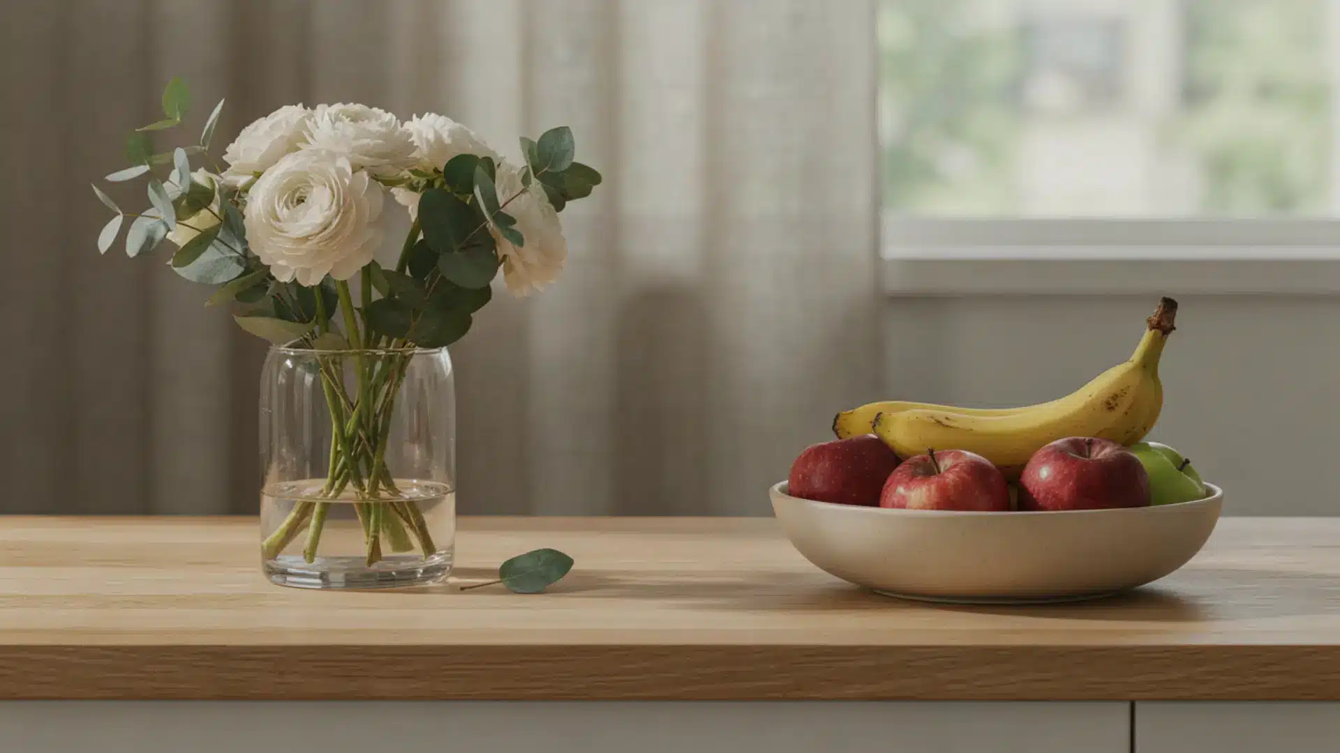 Flower vase and fruit bowl placed apart on a surface