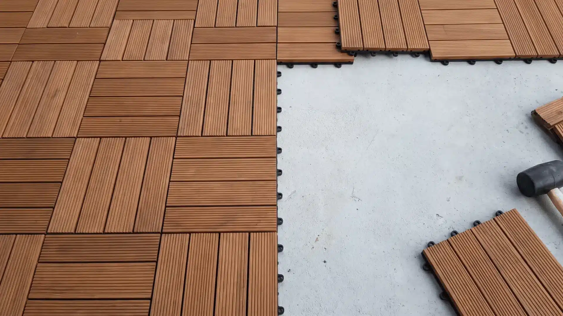 Interlocking deck tiles partially covering a flat concrete patio