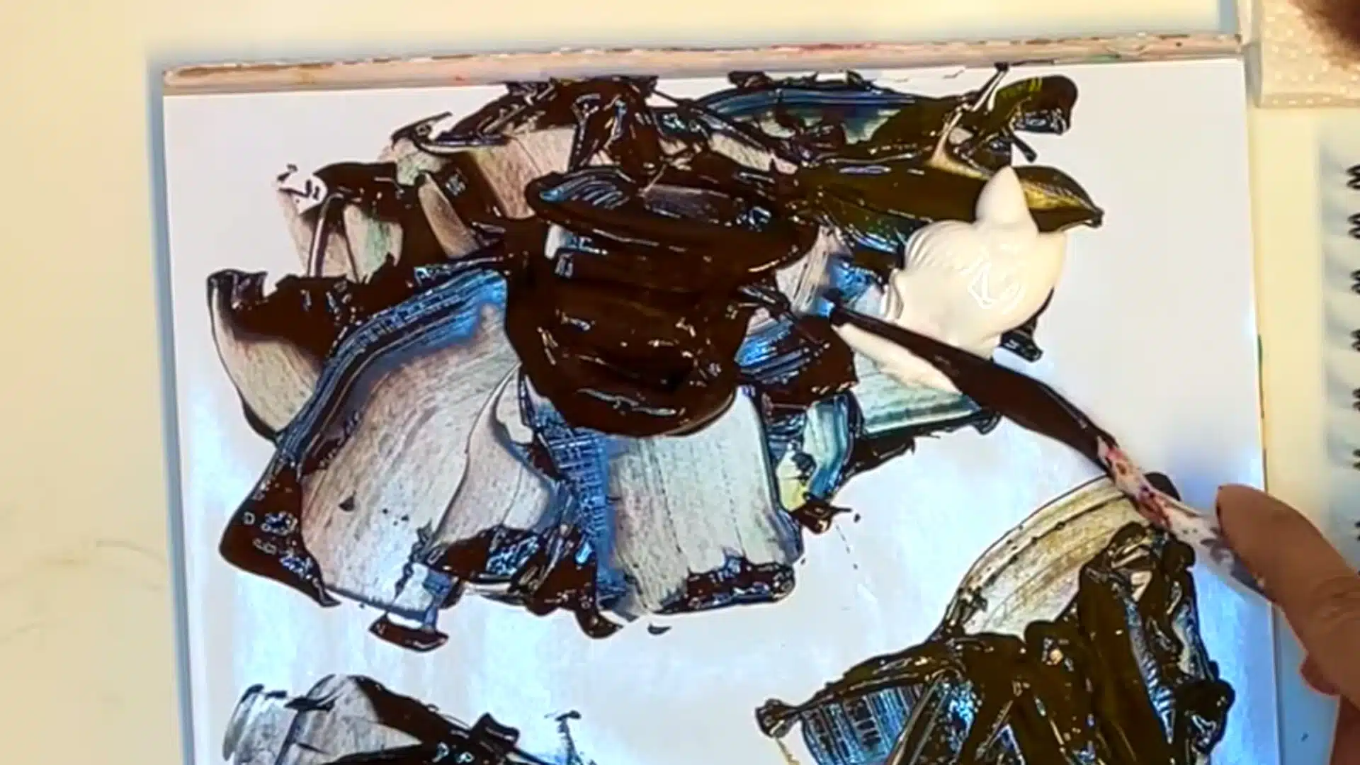 Adding white paint to brown mixtures to create lighter brown tints and shades.