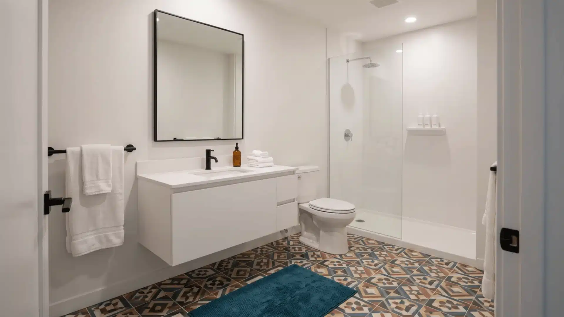 Multicolored patterned floor tile with plain white fixtures and solid textiles in an eclectic bathroom