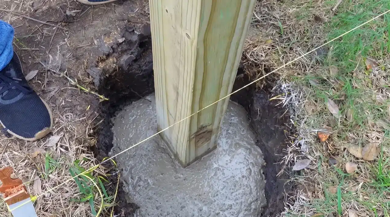 Measuring fence layout and setting a wooden post in concrete for a backyard fence installation