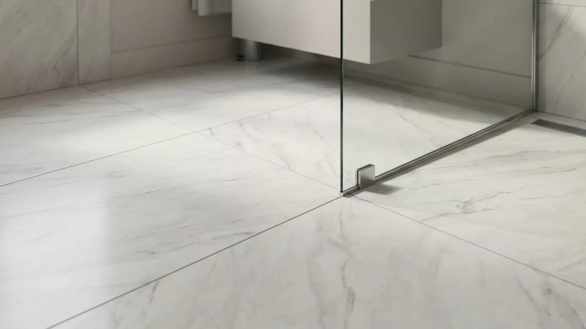 large format porcelain tile flooring installed in a modern bathroom near a glass shower