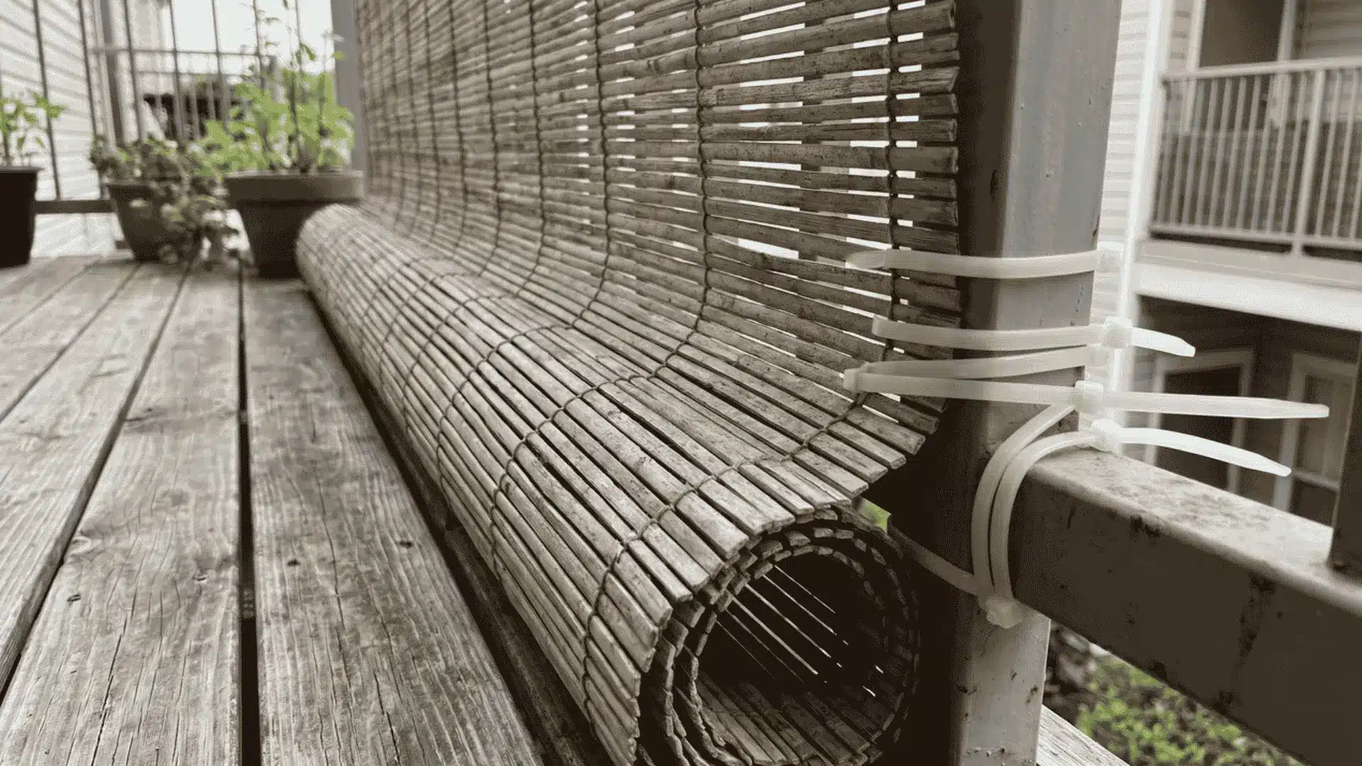 Portable bamboo privacy screen secured to a deck railing with zip ties