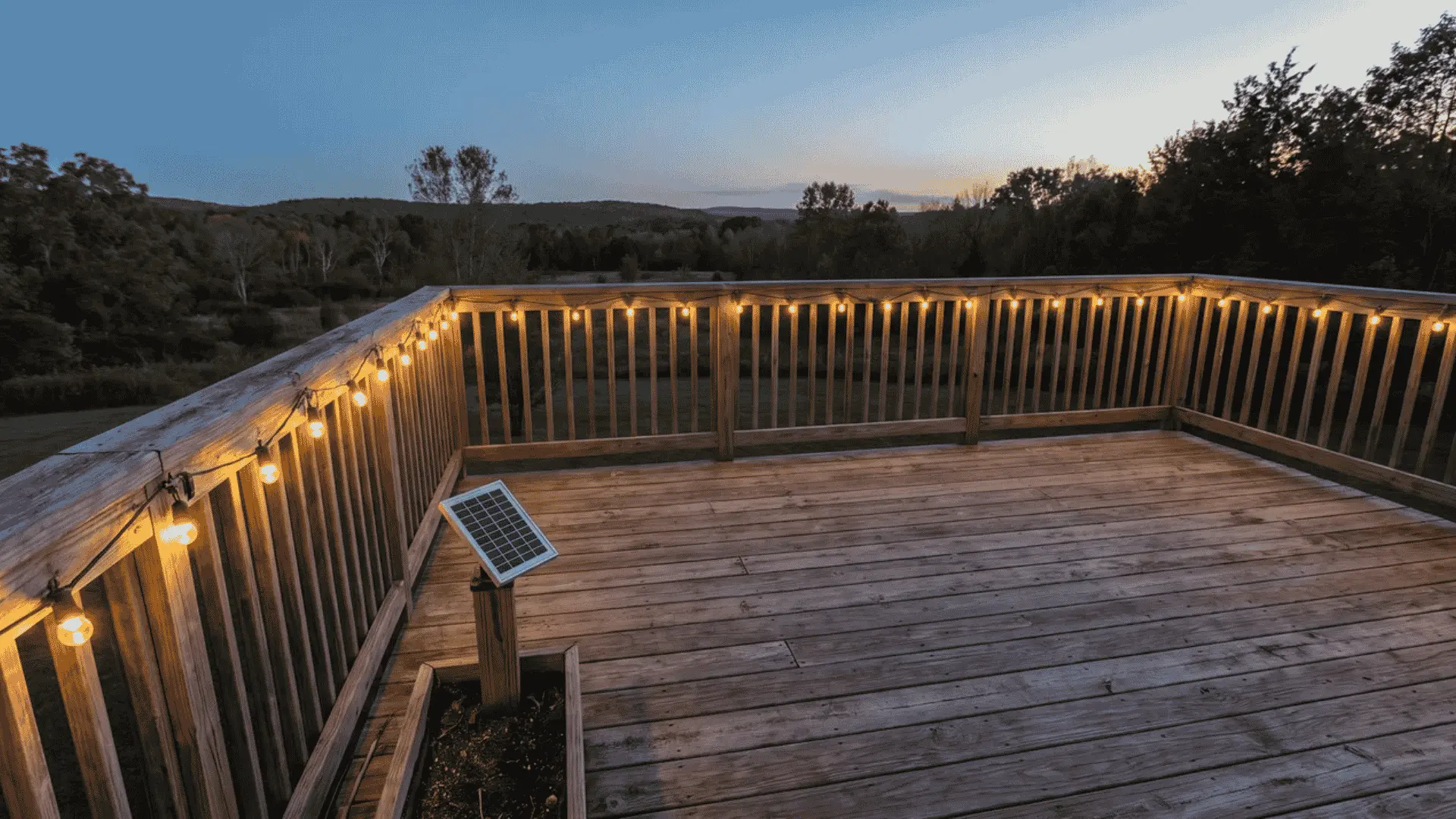 Solar string lights glowing along the perimeter railing of a wooden deck