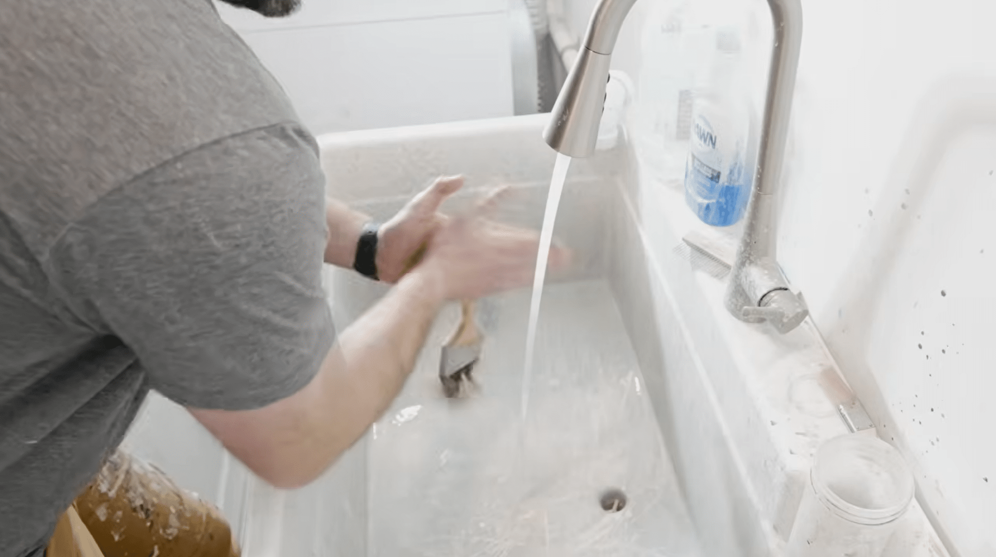 Removing excess water from a paint brush after cleaning before reshaping the bristles.
