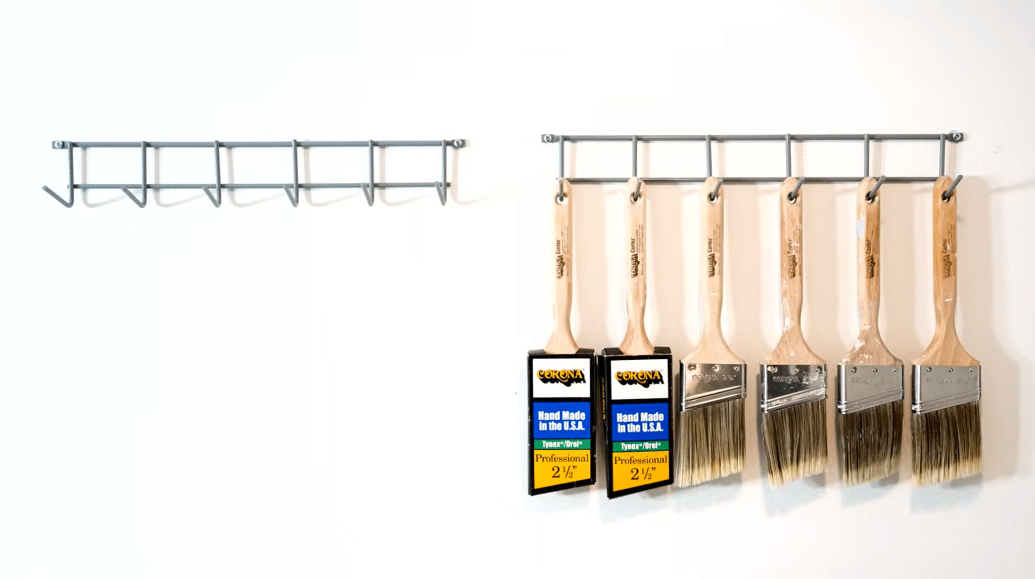 Clean paint brushes hanging on a wall rack with their bristles facing downward for storage.