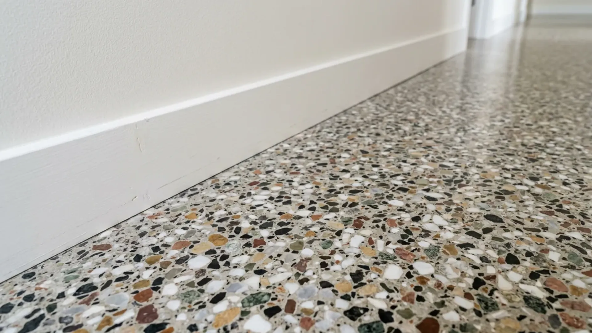 speckled terrazzo flooring with marble and quartz chips installed in a bright hallway