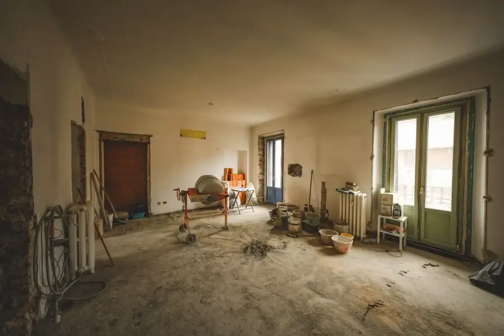 5 Home Renovation Mistakes That Can Lead to Plumbing Problems Construction site in a partially renovated room with cement mixer and tools under warm lighting
