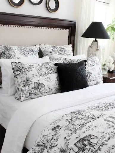 Serena and Lily Bedding Reviews: Is the Bedding Worth the Investment? Cozy bed with patterned pillows and duvet in a softly lit bedroom setting